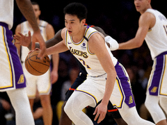 NBA常规赛现场，湖人队球员带球突破防守球员